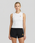 Woman wearing a white sleeveless top and black shorts with a logo on a light gray background
