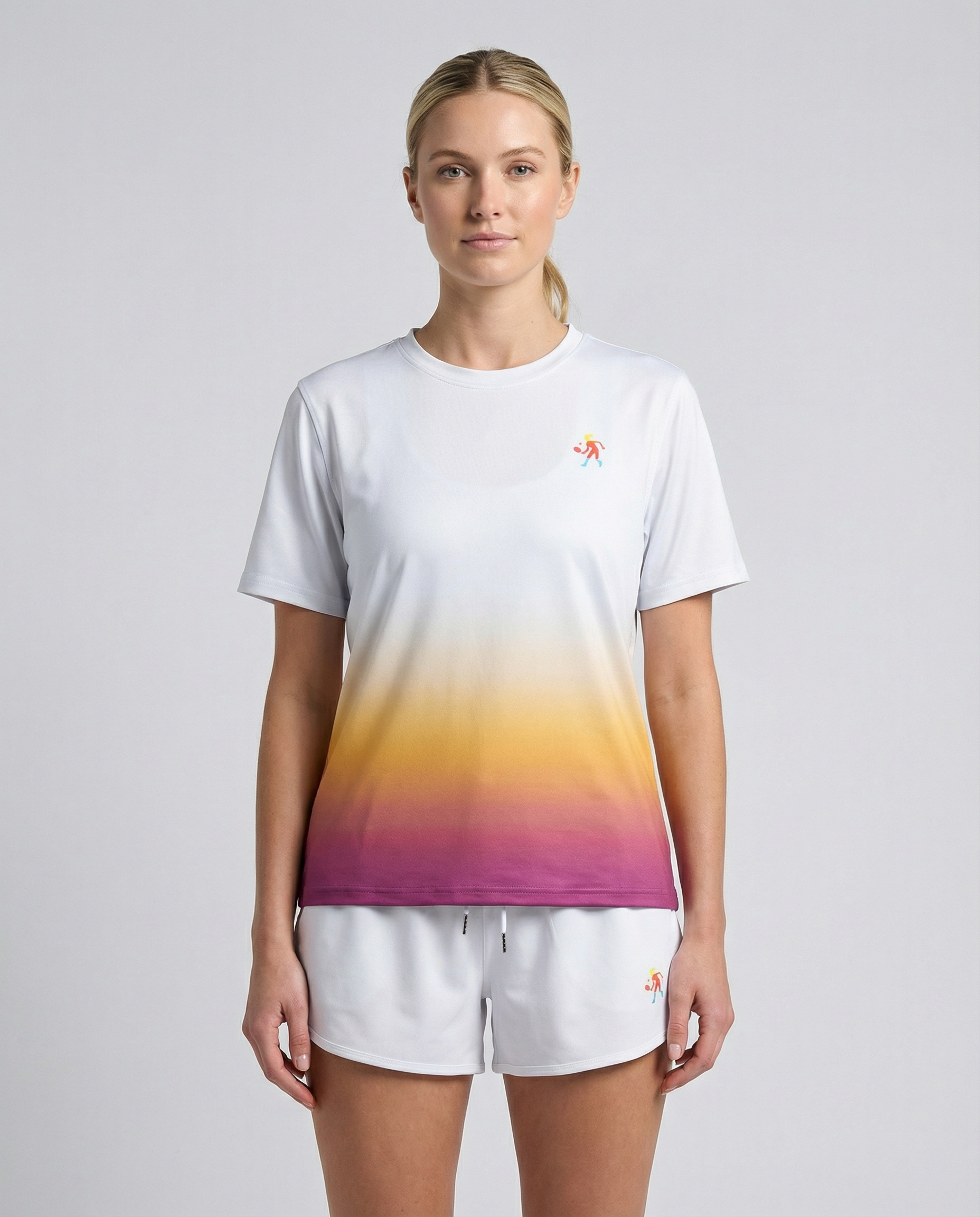 Woman wearing a white t-shirt with a colorful gradient design and matching shorts on a light gray background