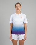 Woman wearing a white to blue gradient t-shirt with a small logo on a gray background