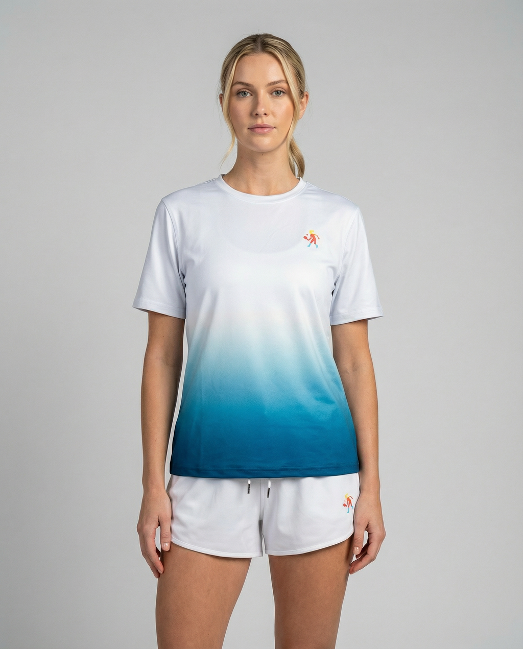 Woman wearing a white and blue gradient t-shirt with a logo on a gray background