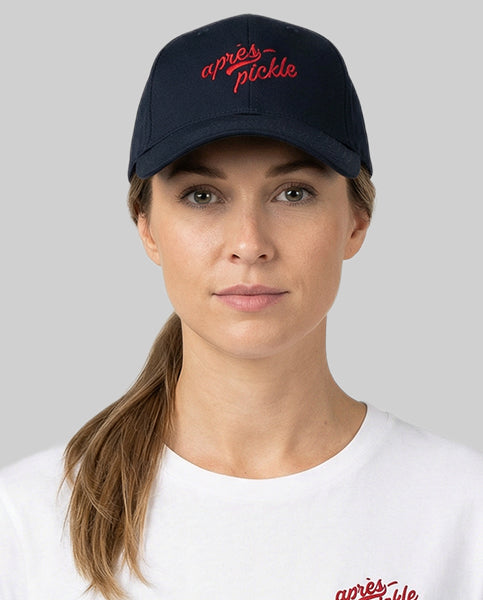 Person wearing a navy cap with red text on a plain background