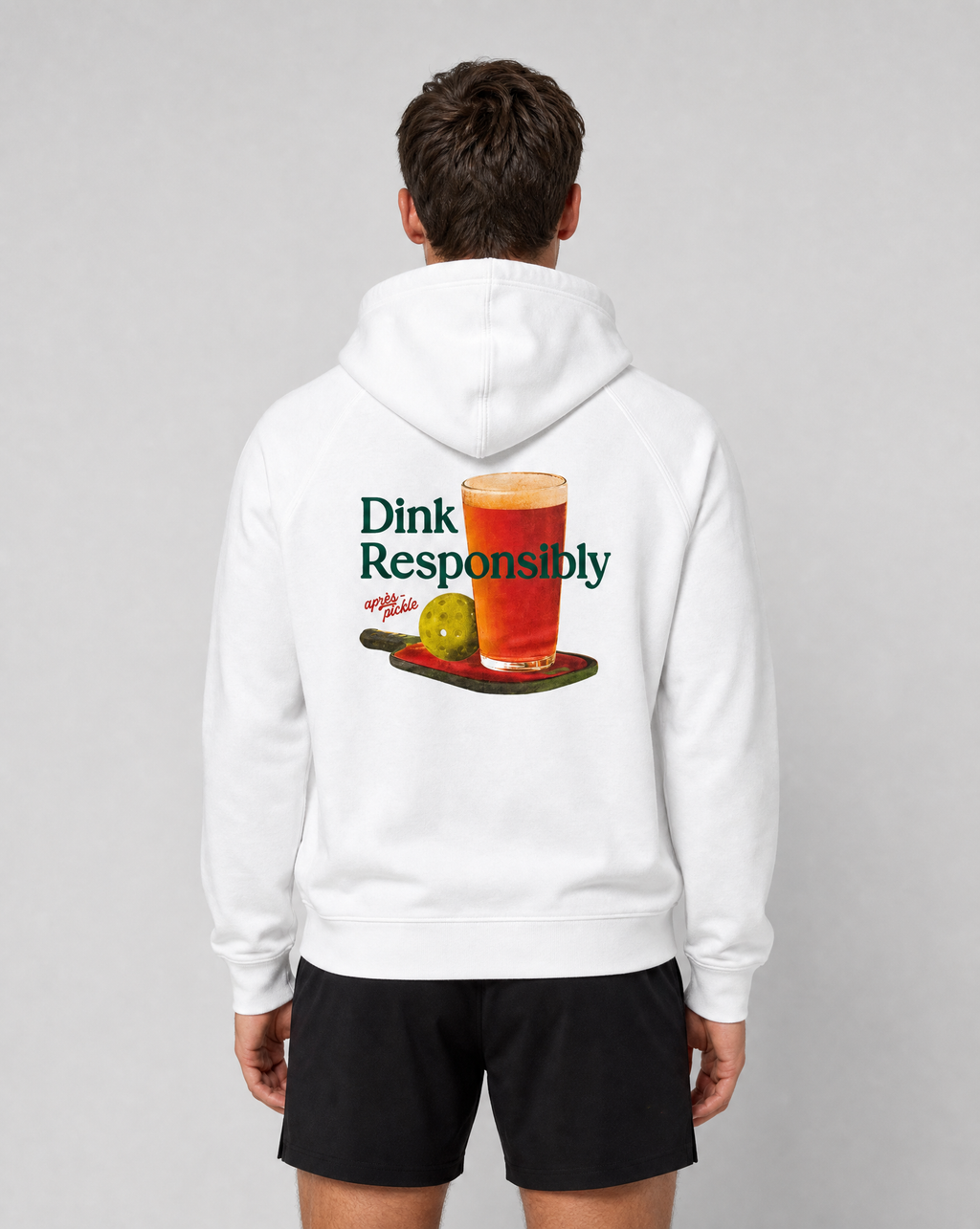 Person wearing a white hoodie with a graphic and text on the back, standing against a plain background.